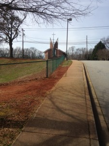 Photo Caption: Today the school principal approached me in the parking lot and mentioned she would like wildflowers in front of the school as well. This strip between the sidewalk and ball field would be ideal.